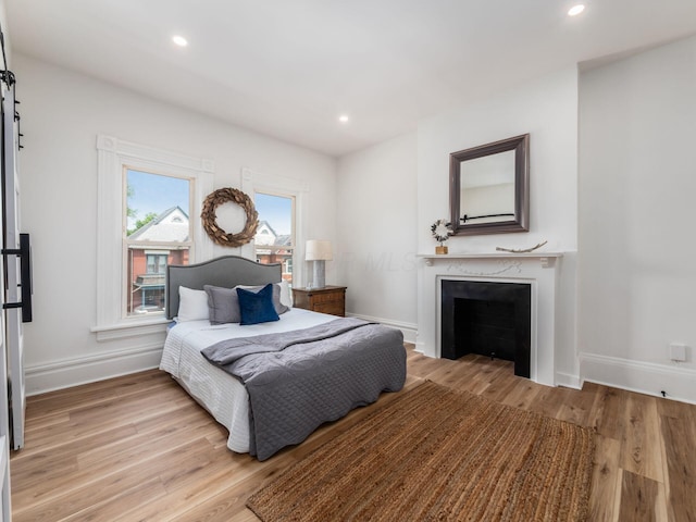 883 Wilson Ave, Columbus, OH 43206 - bedroom with wood finished floors, a fireplace, baseboards, and recessed lighting