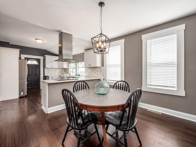 533 Stewart Ave, Columbus, OH 43206 - dining room with a chandelier, dark wood finished floors, baseboards, and vaulted ceiling