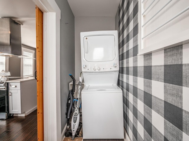 533 Stewart Ave, Columbus, OH 43206 - laundry area with stacked washer / drying machine, wallpapered walls, dark wood finished floors, and baseboards