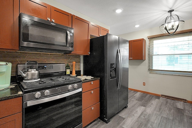 1067 Bronwyn Ave, Columbus, OH 43204 - kitchen with stainless steel range with gas stovetop, fridge with ice dispenser, decorative backsplash, light wood-style floors, and baseboards