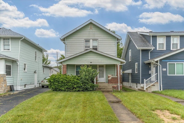476 Graham St, Columbus, OH 43203 - view of front of home featuring a front lawn, covered porch, brick siding, and entry steps