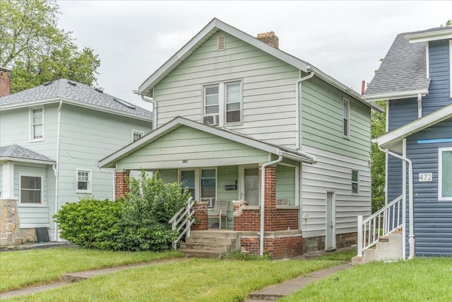 476 Graham St, Columbus, OH 43203 - american foursquare style home featuring covered porch, a chimney, and a front lawn