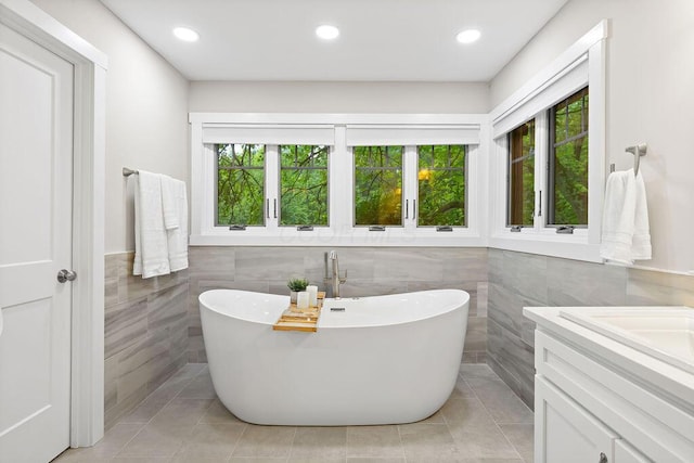 7276 Lee Rd, Westerville, OH 43081 - bathroom featuring tile walls, a freestanding bath, healthy amount of natural light, tile patterned floors, and vanity