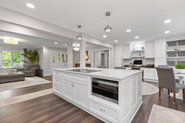 7276 Lee Rd, Westerville, OH 43081 - kitchen with stainless steel microwave, black electric cooktop, open floor plan, white cabinetry, and dark wood-type flooring
