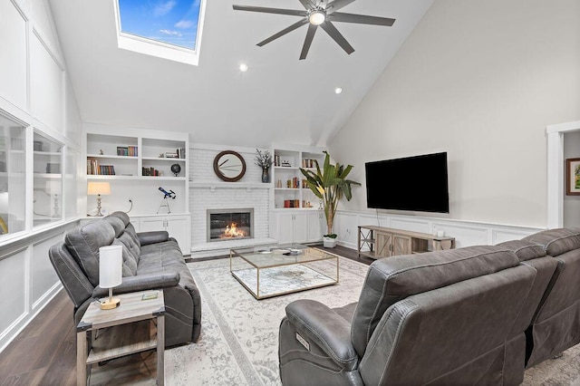 7276 Lee Rd, Westerville, OH 43081 - living area with a ceiling fan, high vaulted ceiling, a brick fireplace, a wainscoted wall, and wood finished floors