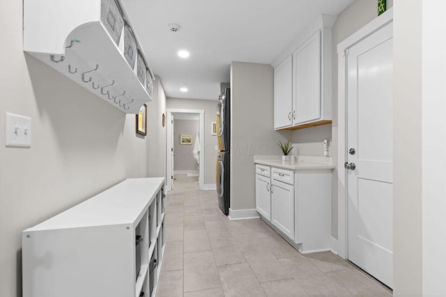 7276 Lee Rd, Westerville, OH 43081 - laundry area featuring stacked washer and clothes dryer, recessed lighting, light tile patterned floors, and baseboards