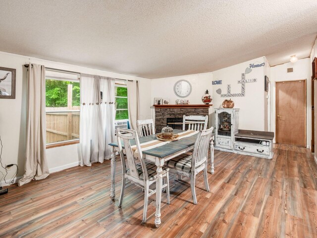 4015 County Road 25, Cardington, OH 43315 - dining area featuring wood finished floors, a textured ceiling, and a fireplace