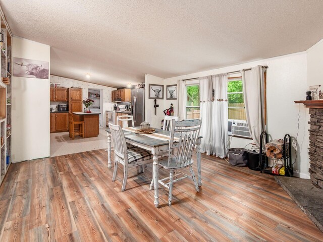 4015 County Road 25, Cardington, OH 43315 - dining room featuring light wood-type flooring, a textured ceiling, lofted ceiling, and a fireplace