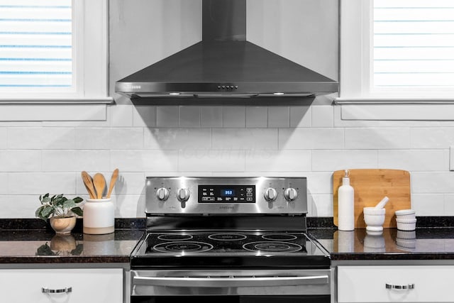 731 Siebert St, Columbus, OH 43206 - kitchen with electric range, wall chimney range hood, white cabinetry, and tasteful backsplash