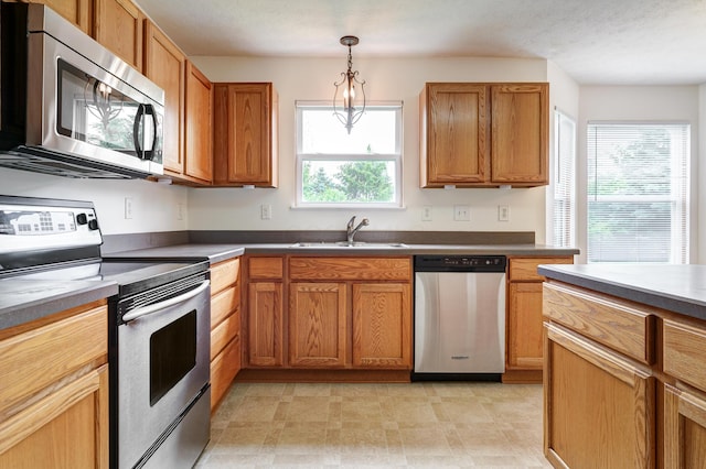 2378 Myrtle Valley Dr, Columbus, OH 43228 - kitchen with appliances with stainless steel finishes, a sink, pendant lighting, and brown cabinetry