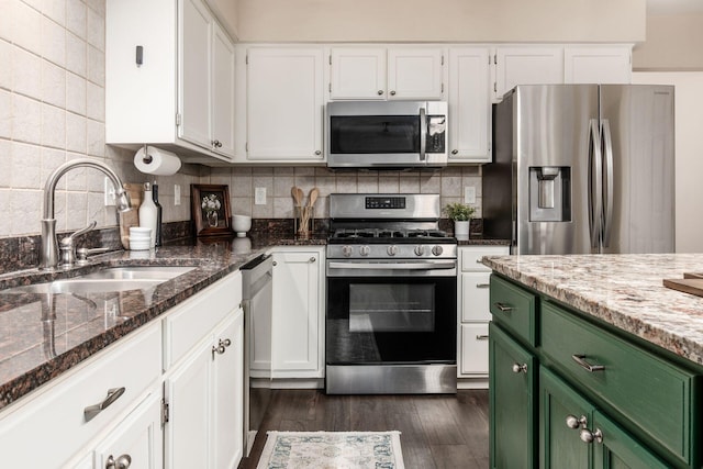 1693 Hale Ct, Columbus, OH 43228 - kitchen featuring appliances with stainless steel finishes, green cabinetry, a sink, white cabinetry, and dark stone countertops