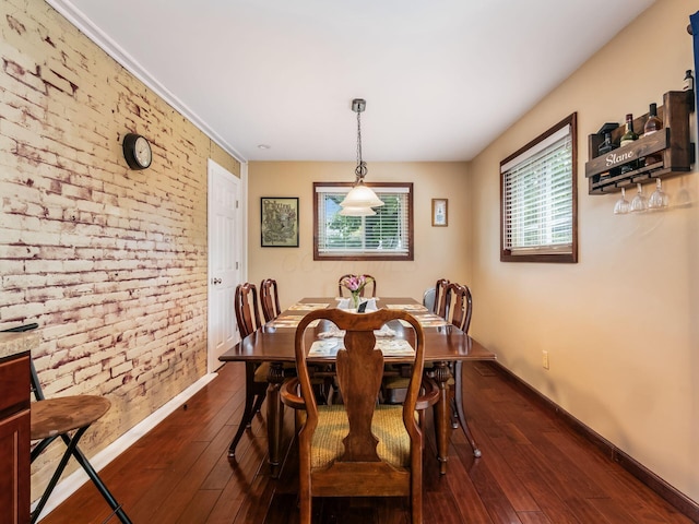 193 W Pearl St, West Jefferson, OH 43162 - dining area with brick wall, baseboards, dark wood-style flooring, and an accent wall