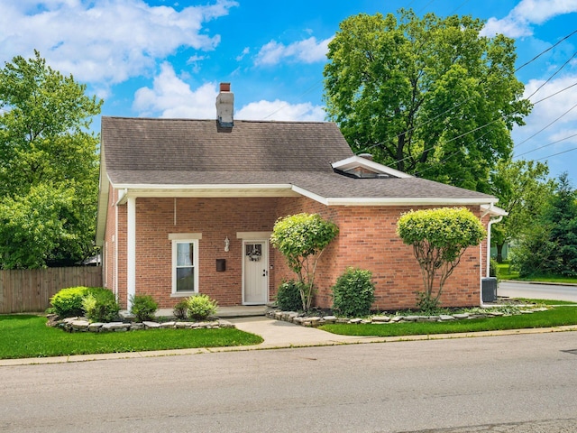 193 W Pearl St, West Jefferson, OH 43162 - view of front of home featuring a chimney, brick siding, a shingled roof, and central AC