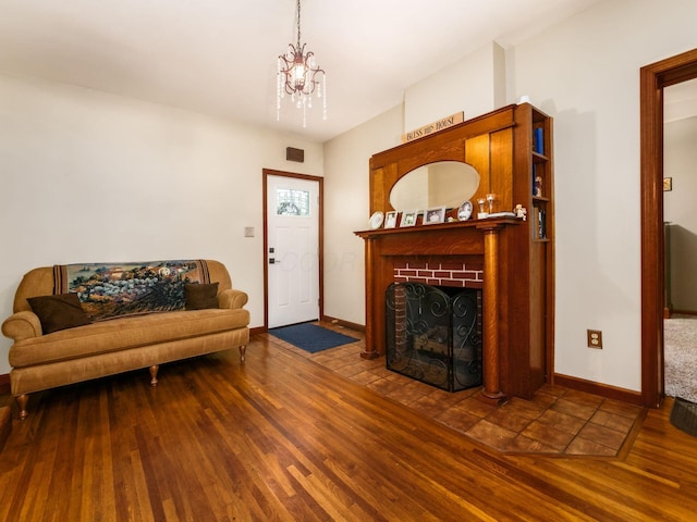 193 W Pearl St, West Jefferson, OH 43162 - living area featuring wood finished floors, baseboards, a chandelier, and a brick fireplace