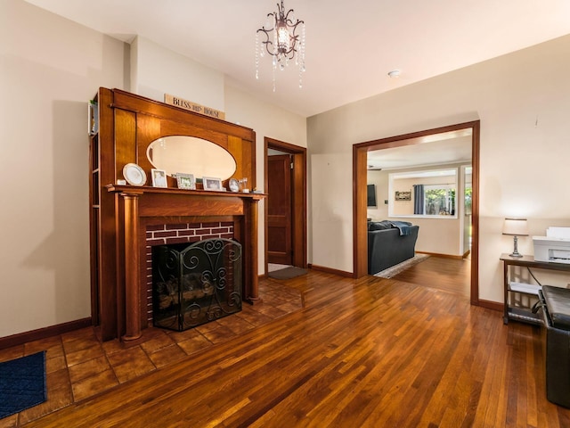 193 W Pearl St, West Jefferson, OH 43162 - living area featuring dark wood-style floors, baseboards, a fireplace, and a chandelier