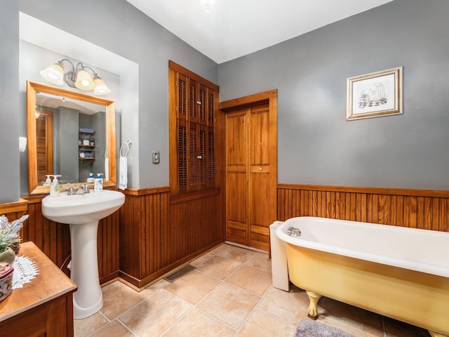 193 W Pearl St, West Jefferson, OH 43162 - bathroom with a soaking tub, wainscoting, tile patterned flooring, and wooden walls