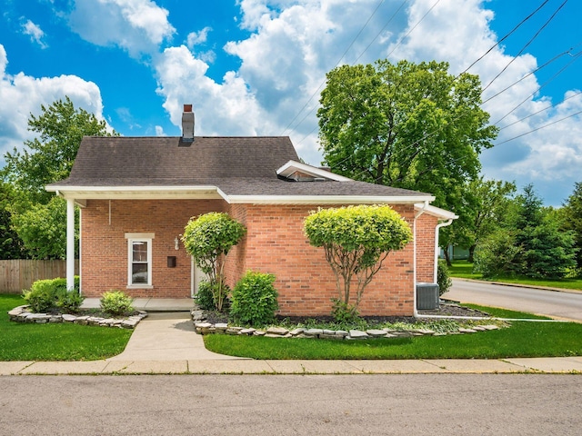 193 W Pearl St, West Jefferson, OH 43162 - view of front of property with a chimney, brick siding, a shingled roof, and central air condition unit