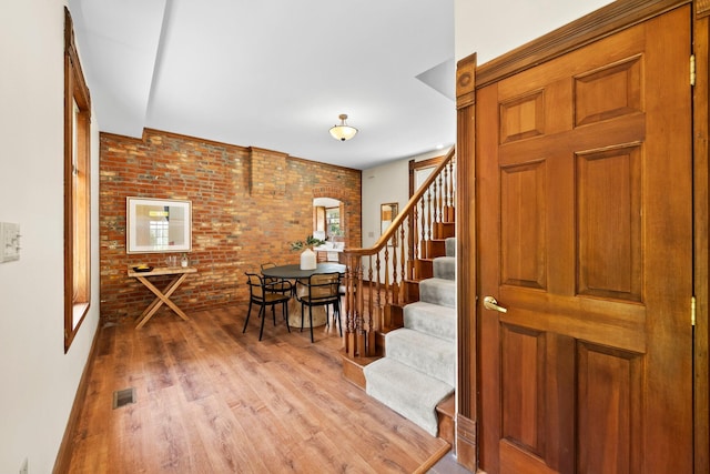 41 Hanford St, Columbus, OH 43206 - entryway featuring stairs, light wood-type flooring, and brick wall