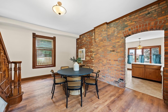 41 Hanford St, Columbus, OH 43206 - dining area with light wood-style floors, plenty of natural light, brick wall, baseboards, and arched walkways