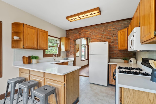 41 Hanford St, Columbus, OH 43206 - kitchen with white appliances, a peninsula, light countertops, a sink, and decorative backsplash