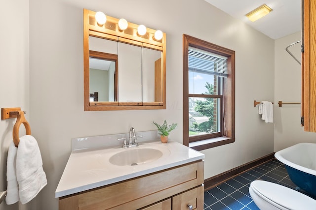 41 Hanford St, Columbus, OH 43206 - full bathroom featuring vanity, a freestanding bath, tile patterned floors, toilet, and baseboards