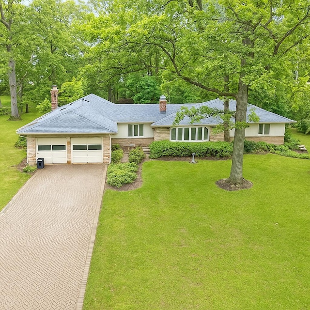 2692 Jordan Rd, Columbus, OH 43231 - view of front facade featuring a chimney, decorative driveway, a garage, and a front yard