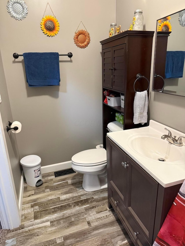 205 Walnut St, Circleville, OH 43113 - half bathroom with vanity, wood finished floors, toilet, and baseboards