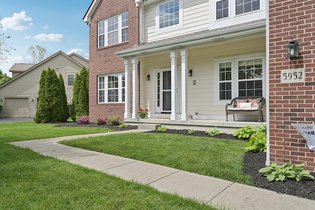 5952 Hampton Cors S, Hilliard, OH 43026 - traditional home with covered porch, brick siding, and a front lawn