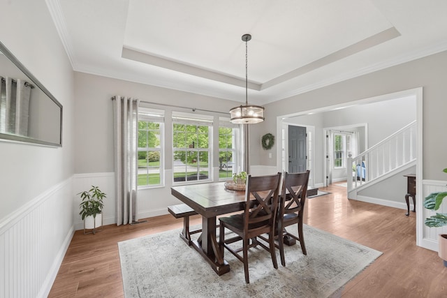 5952 Hampton Cors S, Hilliard, OH 43026 - dining room featuring light wood-style floors, a tray ceiling, stairs, and crown molding