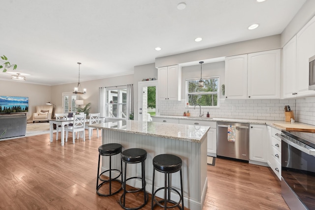 5952 Hampton Cors S, Hilliard, OH 43026 - kitchen with appliances with stainless steel finishes, light wood-type flooring, light stone countertops, backsplash, and open floor plan