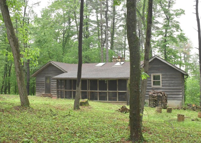 311 Chinook Ln, Sugar Grove, OH 43155 - back of property featuring a sunroom, a chimney, and roof with shingles