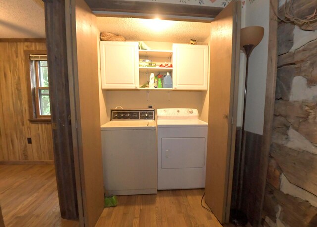 311 Chinook Ln, Sugar Grove, OH 43155 - washroom featuring cabinet space, washer and dryer, light wood-style flooring, and wood walls