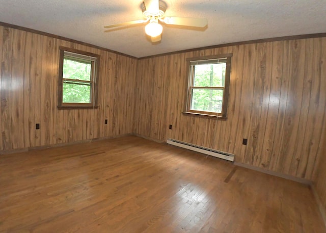 311 Chinook Ln, Sugar Grove, OH 43155 - empty room with a baseboard heating unit, a textured ceiling, ceiling fan, wood finished floors, and wood walls