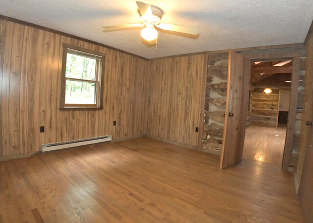 311 Chinook Ln, Sugar Grove, OH 43155 - unfurnished room featuring a baseboard radiator, a ceiling fan, a textured ceiling, wood finished floors, and wood walls