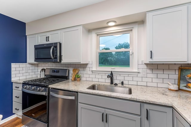 5786 Thompson Rd, Columbus, OH 43230 - kitchen with stainless steel appliances, a sink, backsplash, and light stone countertops