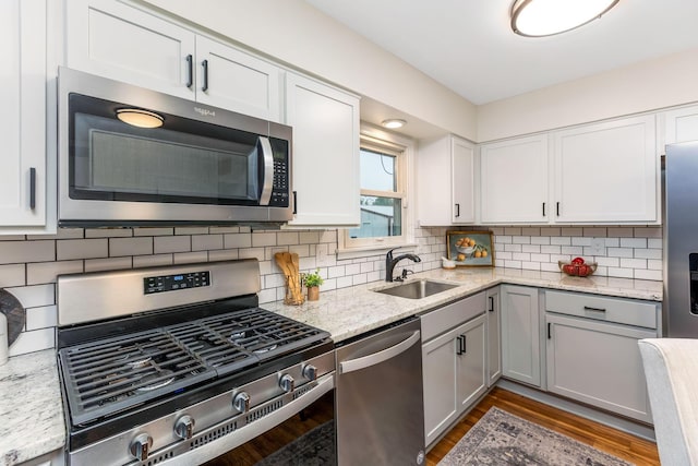 5786 Thompson Rd, Columbus, OH 43230 - kitchen with appliances with stainless steel finishes, a sink, tasteful backsplash, dark wood-style floors, and light stone countertops