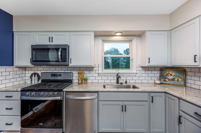 5786 Thompson Rd, Columbus, OH 43230 - kitchen with stainless steel appliances, a sink, backsplash, and light stone countertops