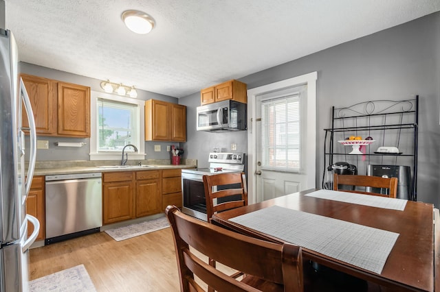 526 N Columbus St, Lancaster, OH 43130 - kitchen featuring stainless steel appliances, a sink, plenty of natural light, a textured ceiling, and light wood-style floors