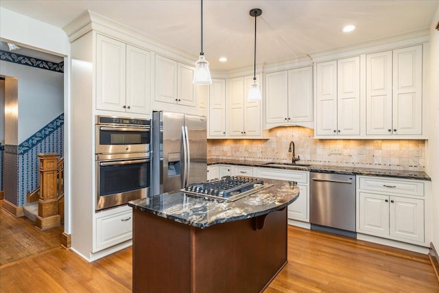 355 W 7th Ave, Columbus, OH 43201 - kitchen featuring stainless steel appliances, a sink, light wood finished floors, dark stone counters, and white cabinetry