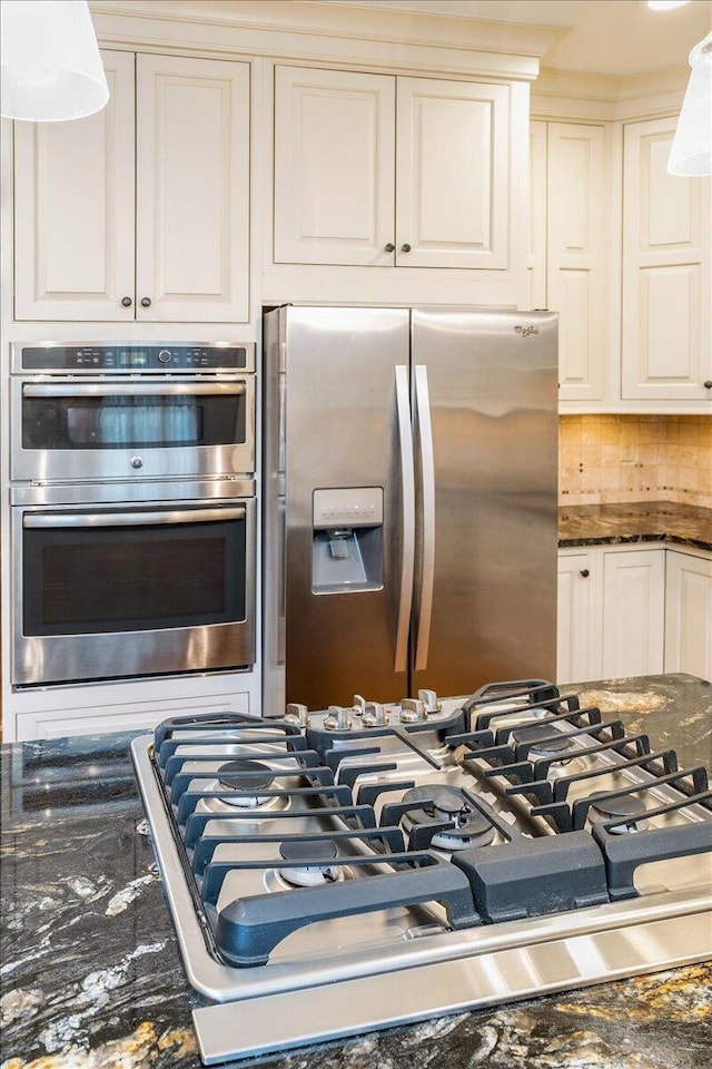 355 W 7th Ave, Columbus, OH 43201 - kitchen featuring stainless steel appliances, dark stone counters, white cabinets, pendant lighting, and backsplash