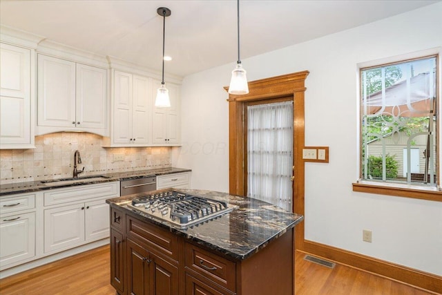 355 W 7th Ave, Columbus, OH 43201 - kitchen with a sink, stainless steel appliances, light wood finished floors, backsplash, and white cabinets
