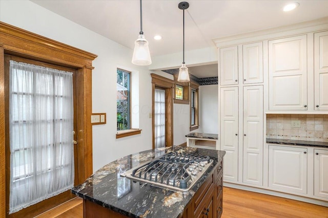 355 W 7th Ave, Columbus, OH 43201 - kitchen featuring stainless steel gas stovetop, light wood-style flooring, a center island, dark stone countertops, and white cabinets