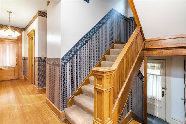 355 W 7th Ave, Columbus, OH 43201 - stairs with a wainscoted wall, wallpapered walls, wood finished floors, and a chandelier
