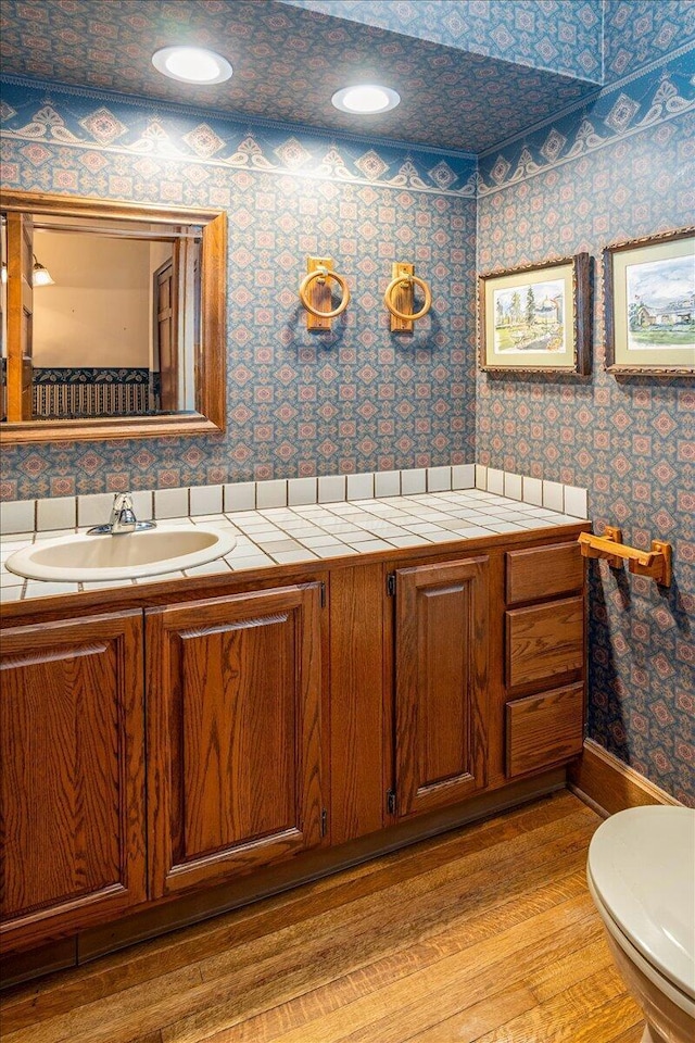355 W 7th Ave, Columbus, OH 43201 - bathroom featuring toilet, wood finished floors, vanity, wallpapered walls, and recessed lighting