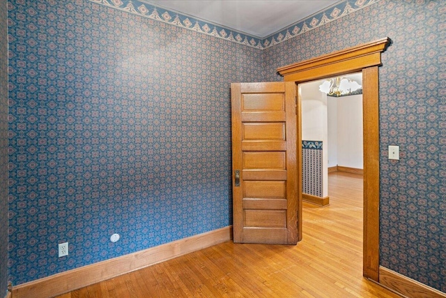 355 W 7th Ave, Columbus, OH 43201 - spare room featuring wood finished floors, baseboards, a chandelier, and wallpapered walls