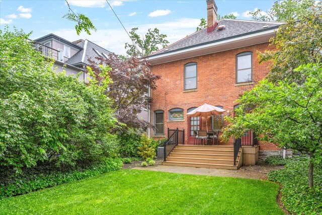 355 W 7th Ave, Columbus, OH 43201 - back of property with a lawn, brick siding, a chimney, and a deck