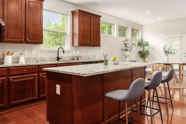 7019 Blakemore Ln, Dublin, OH 43016 - kitchen with a sink, dark wood-style floors, a kitchen island, a breakfast bar, and recessed lighting