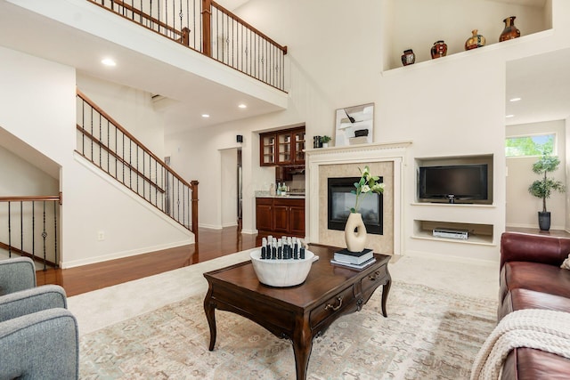 7019 Blakemore Ln, Dublin, OH 43016 - carpeted living room with stairway, a high ceiling, baseboards, a tile fireplace, and recessed lighting