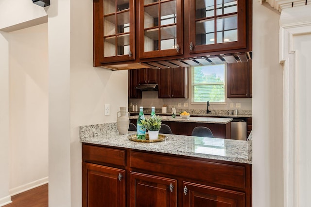 7019 Blakemore Ln, Dublin, OH 43016 - kitchen with glass insert cabinets, light stone counters, a sink, and decorative backsplash