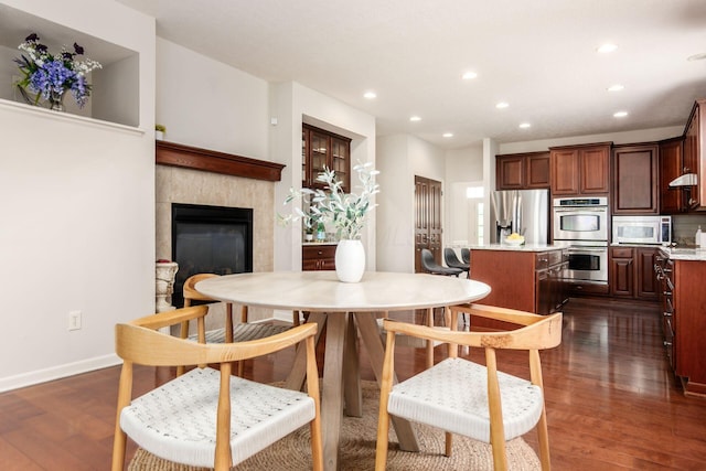 7019 Blakemore Ln, Dublin, OH 43016 - dining area featuring recessed lighting, dark wood-style flooring, baseboards, and a tile fireplace